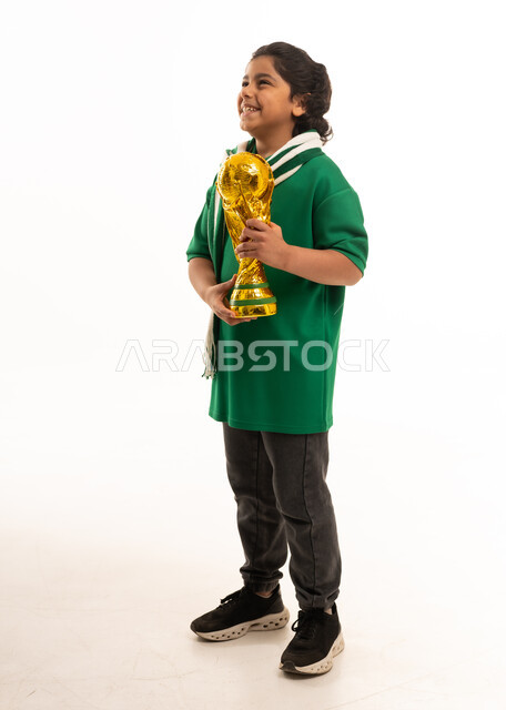 طفل سعودي يحمل مجسم كأس العالم الذهبي