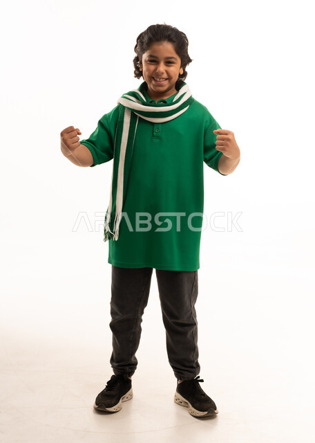 طفل سعودي يحتفل بقميص ووشاح أخضر