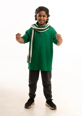 طفل سعودي يحتفل بقميص ووشاح أخضر