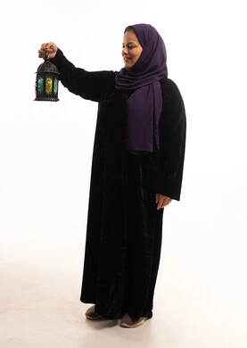 امرأة سعودية بالعباية تحمل فانوس رمضان التقليدي