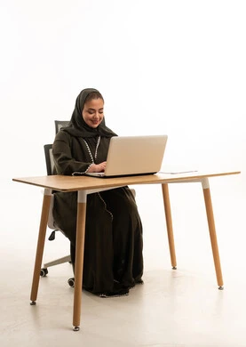 Saudi Woman Working on Laptop at Office Desk