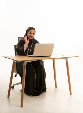 امرأة سعودية بالعباءة تلوح بمكالمة فيديو عبر المحمول