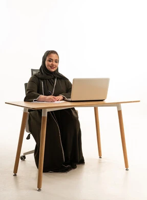 سيدة أعمال إماراتية بالعباية مع لابتوب في الاستوديو
