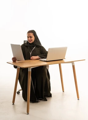 Emirati Businesswoman in Green Abaya Working at Desk