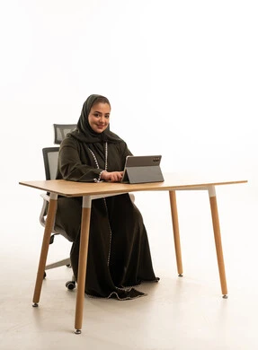 Saudi Woman in Abaya Using Tablet at Office Desk