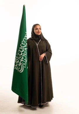 Saudi Woman in Abaya Holding Saudi Arabia Flag