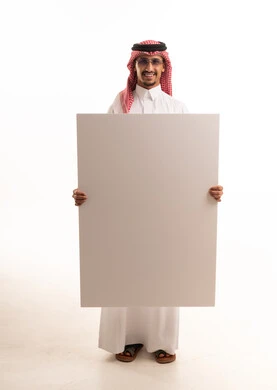 رجل سعودي بالزي التقليدي يحمل لوحة بيضاء فارغة