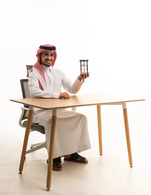 Saudi Man at Office Desk Holding an Hourglass
