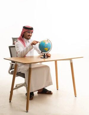 Saudi Man in Traditional Thobe Pointing at Globe