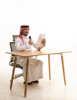 Saudi Businessman Holding Microphone at Desk