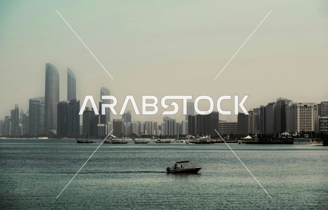 أفق مدينة أبوظبي والواجهة البحرية مع قارب بمحرك