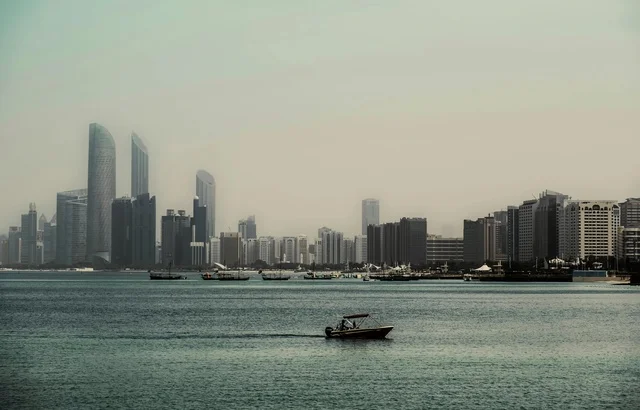 أفق مدينة أبوظبي والواجهة البحرية مع قارب بمحرك