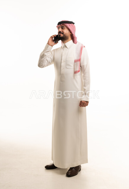 Saudi Man in Traditional Thobe Using Smartphone