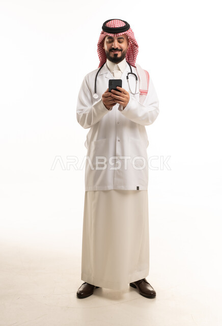 طبيب سعودي بالزي التقليدي يستخدم الهاتف الذكي
