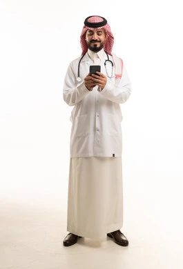 طبيب سعودي بالزي التقليدي يستخدم الهاتف الذكي