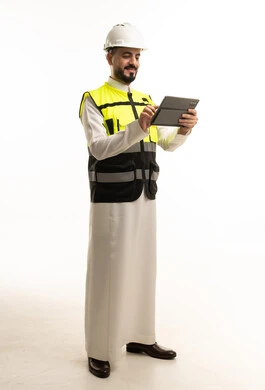 مهندس سعودي بالثوب التقليدي يستخدم جهاز لوحي بخلفية بيضاء