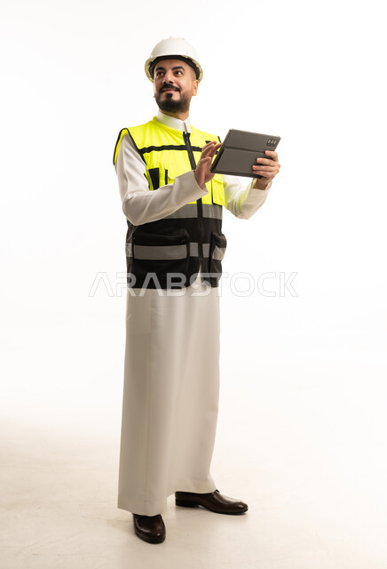 مهندس سعودي بالثوب التقليدي يستخدم جهاز لوحي