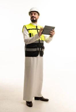 مهندس سعودي بالثوب التقليدي يستخدم جهاز لوحي