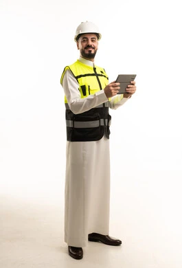 مهندس سعودي بالثوب والخوذة يمسك بجهاز لوحي