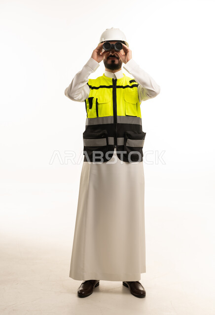 مهندس سعودي بزي السلامة يستخدم المنظار