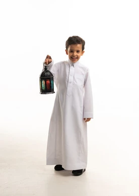 طفل سعودي بالثوب التقليدي يحمل فانوس رمضان