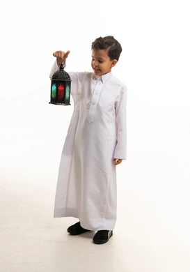 طفل سعودي بالثوب الأبيض يحمل فانوس رمضان