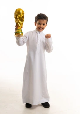 طفل سعودي يحمل مجسم كأس العالم الذهبي
