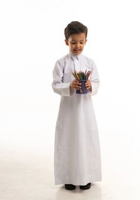 طفل سعودي بالثوب التقليدي يحمل أقلام تلوين