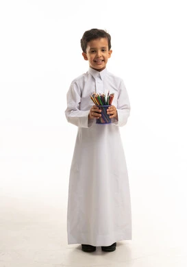 طفل سعودي بالثوب التقليدي يحمل أقلام تلوين