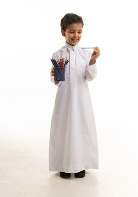 طفل سعودي بالثوب الأبيض مع أقلام ملونة