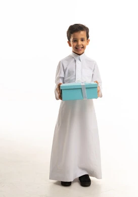طفل سعودي بالثوب الأبيض يحمل علبة هدايا زرقاء