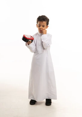 طفل سعودي بالثوب التقليدي يحمل علبة طعام