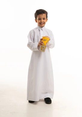 طفل سعودي بالثوب الأبيض يمسك علبة فشار