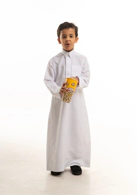 طفل سعودي بالثوب التقليدي يحمل علبة فشار