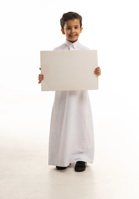 طفل سعودي بالثوب التقليدي يحمل لوحة فارغة