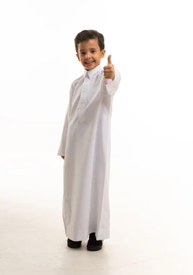 طفل سعودي بالثوب الأبيض يشير بعلامة الإعجاب