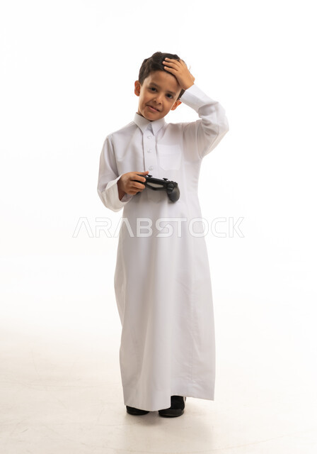 Saudi Boy in White Thobe Holding Gaming Controller