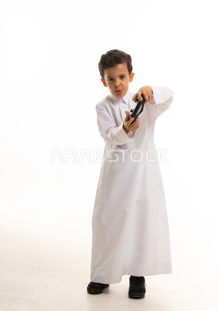 Saudi Boy in Traditional Thobe Playing Video Games