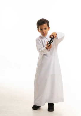 طفل سعودي بالثوب الأبيض يلعب ألعاب الفيديو