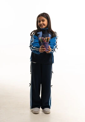 طالبة سعودية بالزي المدرسي تمسك أقلام ملونة طالبة سعودية بالزي المدرسي تمسك أقلام ملونة