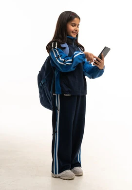 طفلة سعودية بالزي المدرسي مع جهاز لوحي