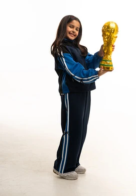طفلة سعودية بملابس رياضية تحمل كأساً ذهبياً