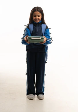 طالبة سعودية بالزي الرياضي تحمل صندوق غداء