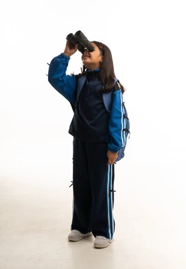 طالبة سعودية بالزي المدرسي تستخدم المنظار بخلفية بيضاء