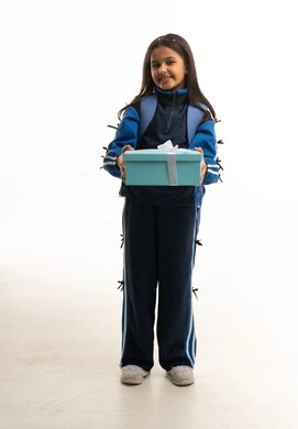 طفلة سعودية بزي مدرسي تحمل صندوق هدايا