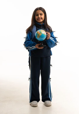 طالبة سعودية بالزي المدرسي تمسك مجسم الكرة الأرضية