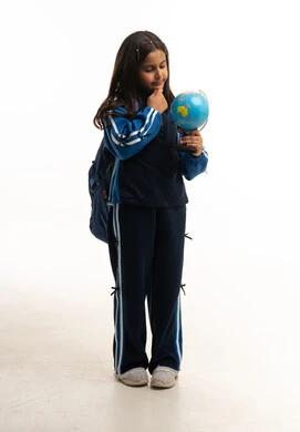 طالبة سعودية مع مجسم الكرة الأرضية بخلفية بيضاء