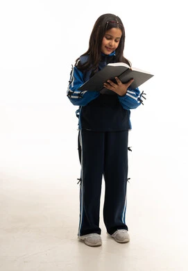 طالبة سعودية تقرأ كتاباً بالزي الرياضي المدرسي