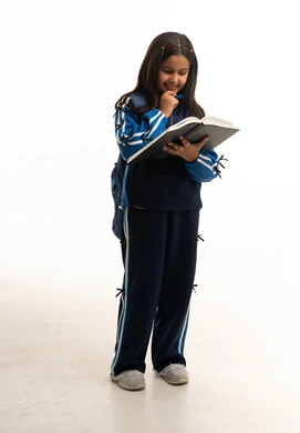 طالبة مدرسة سعودية بالزي الرياضي المدرسي تقرأ كتاباً