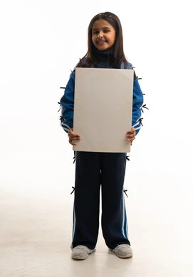 طفلة سعودية بالملابس الرياضية تمسك لوحة بيضاء فارغة